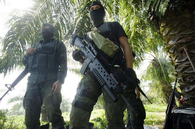 Malaysian police commandos stand guard 2.5 kilometers away from Kampung Tanduo, during a standoff with armed supporters of a Filipino sultan in Malaysia''s Sabah state. Five police and two fighters were killed in a clash in the eastern Malaysian state where the sultan''s followers are demanding their ancestral land rights.