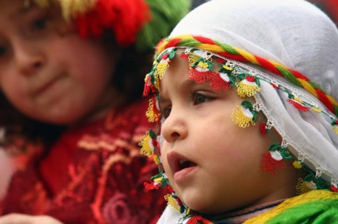 A girl looks on as Kurds gather to cele