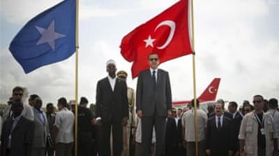 In this 2011 photo Erdogan, right, and Somalia's former President Sheikh Sharif Ahmed stand in front of their countries' national flags as they listen to the national anthems after Erdogan arrived in Mogadishu. [Reuters]