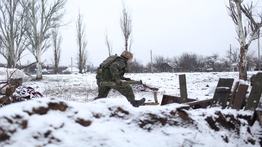 A member of the Sich Battalion runs from a trench to fire a shoulder-fired rocket at rebel positions [John Wendle] 