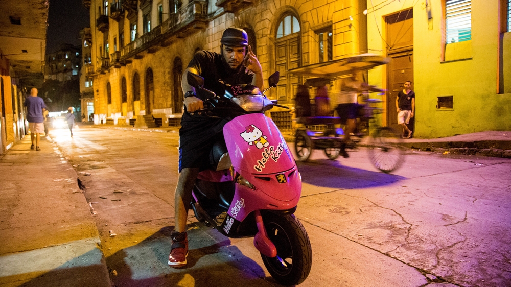 Noslem promotes Faraon and Barbaro's music, riding around Havana with a USB stick and transferring mp3s and roughly cut music videos to underground digital media dealers [Tomas Ayuso/Al Jazeera]