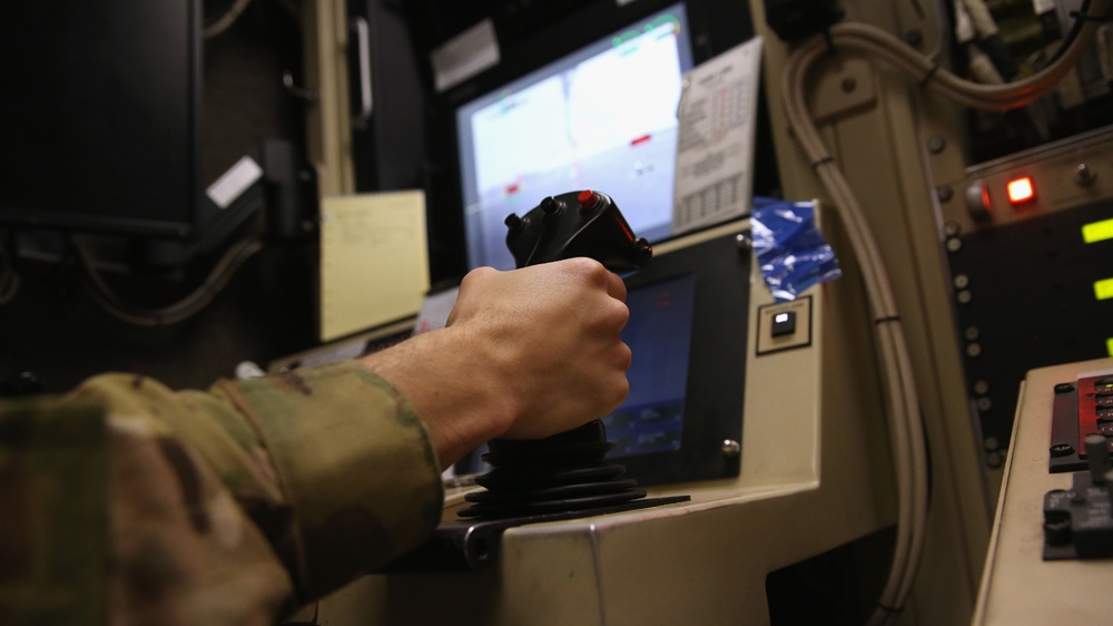 A US Air Force pilot grasps a flight control and weapons firing stick while preparing to launch a MQ-1B Predator unmanned aerial vehicle (UAV), from a ground control station at a secret airbase in the Persian Gulf region on January 7, 2016