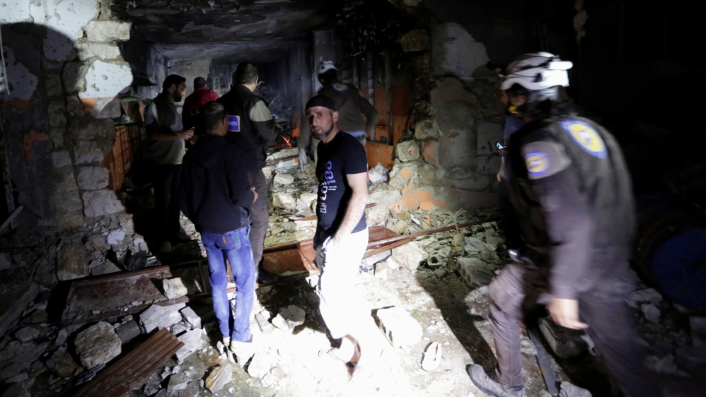 Civilians and civil defence members look for survivors at a site damaged after Russian air strikes on the Syrian rebel-held city of Idlib