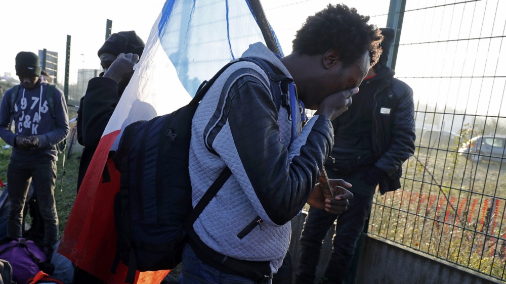 Adam, a Sudanese man who lived in the Jungle for eight months, weeps as he leaves the camp [Reuters]