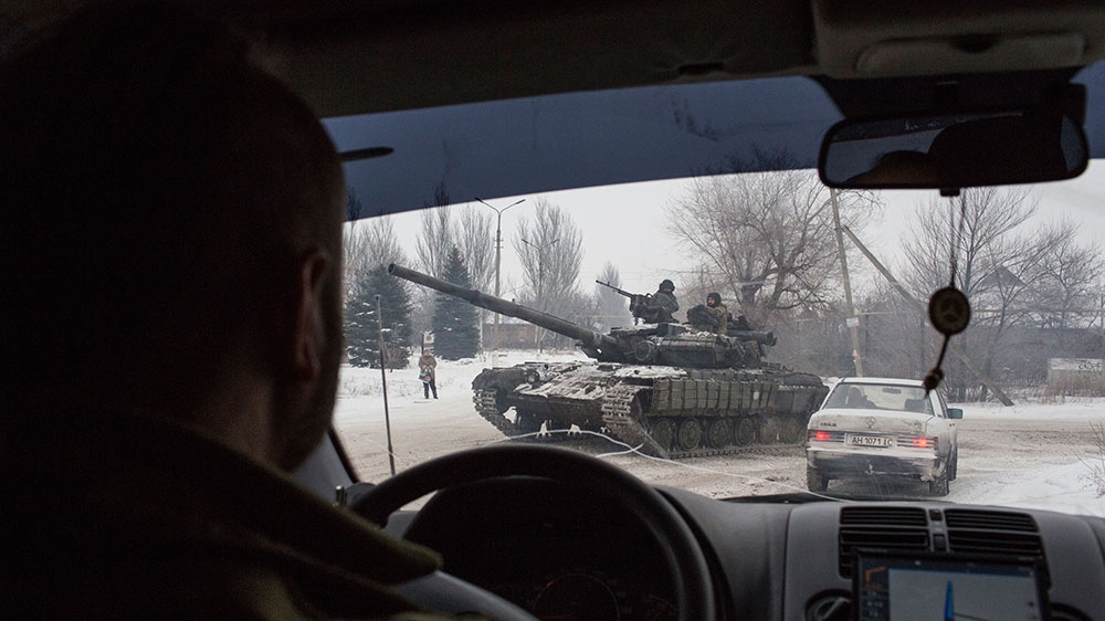 A Ukrainian tank drives through the streets of the embattled town of Avdiivka, on the frontline of the war in Ukraine [John Wendle/Al Jazeera]