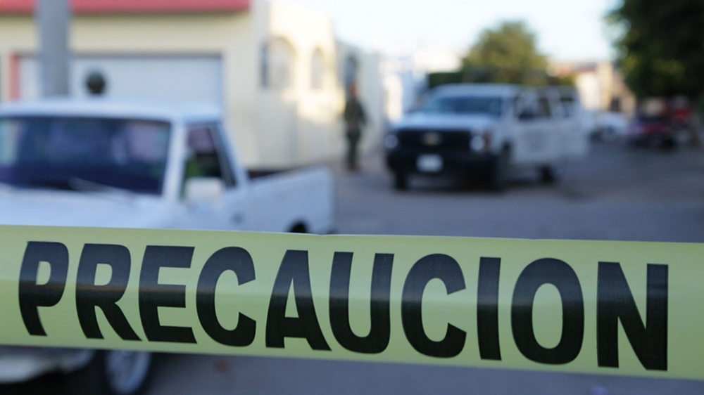 The streets of Villas del Real, a neighbourhood in Culiacan, are closed off with yellow crime-scene tape after a gun battle between marines and civilians [Al Jazeera] 