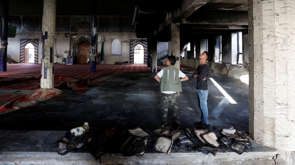Afghans stand inside the Imam Zaman mosque after Friday's attack [Mohammad Ismail/Reuters]