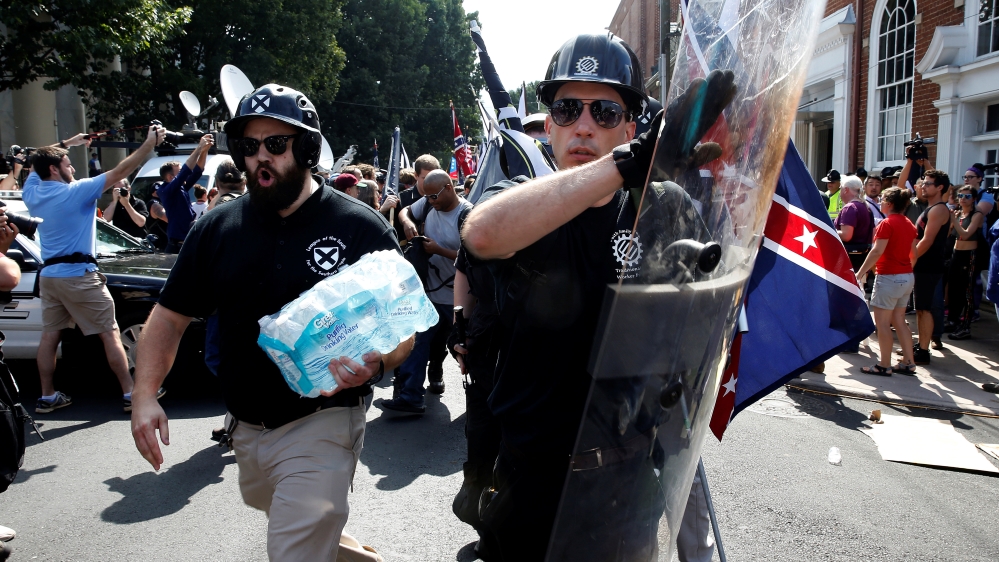 A white supremacist bangs his shield as he arrives at a rally in Charlottesville, Virginia