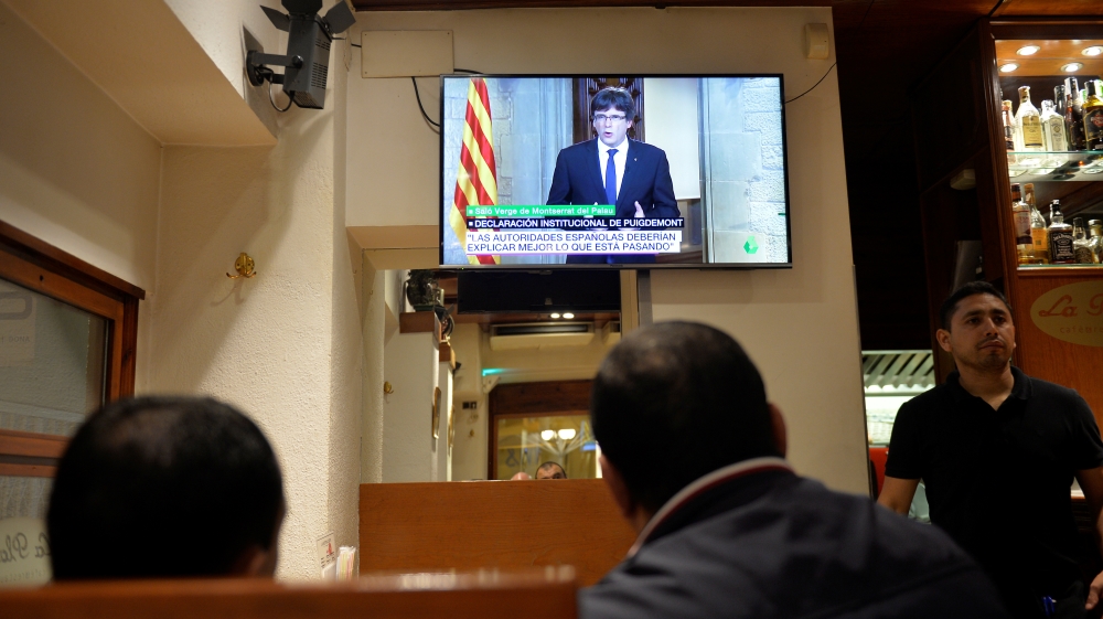 Customers at a bar watch as Catalan President Carles Puigdemont makes a televised address to the nation in Vic, Spain