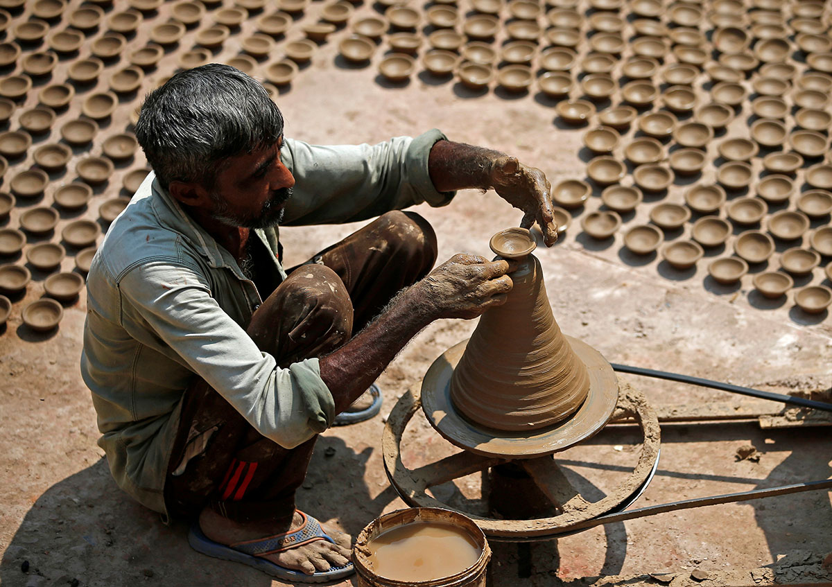 A man makes earthen lamps which are used to decorate temples and homes during the Hindu festival of Diwali, at a workshop in Ahmedabad, India October 10, 2017. REUTERS/Amit Dave