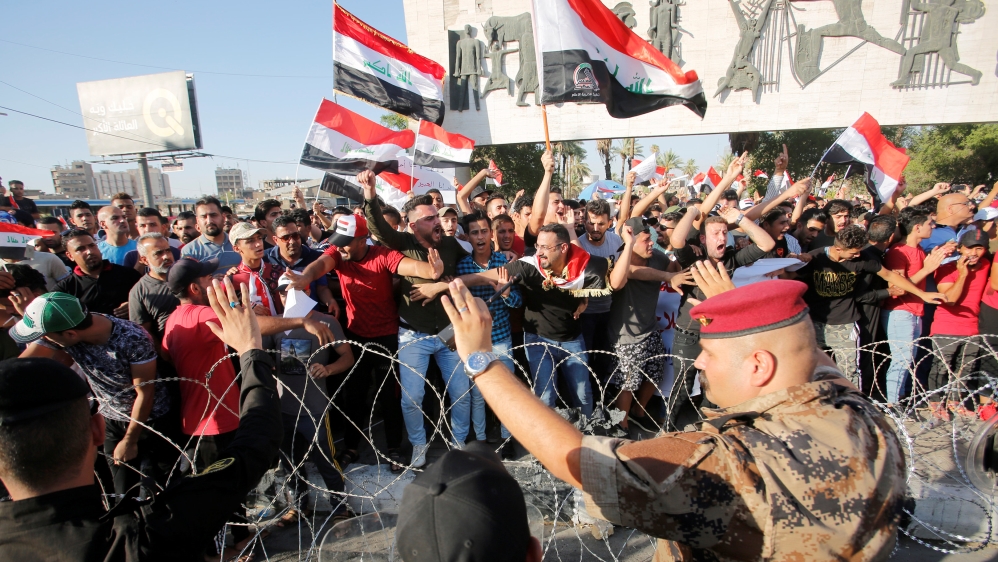 Protesters being dispersed by riot police during a protest in Baghdad, in 2018