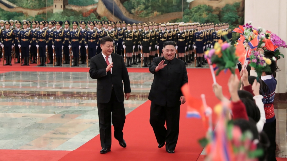 Chinese President Xi Jinping and North Korean leader Kim Jong Un walk down a red carpet at the Great Hall of the People in Beijing, China.