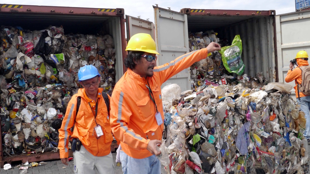A November 2014 photo showing customs officials at Manila port inspecting containers containing tonnes of rubbish shipped by Canada
