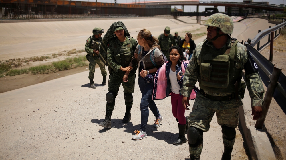 Members of Mexico’s National Guard escort a woman and her daughter from Nicaragua after detaining them as they were trying to cross illegally the border