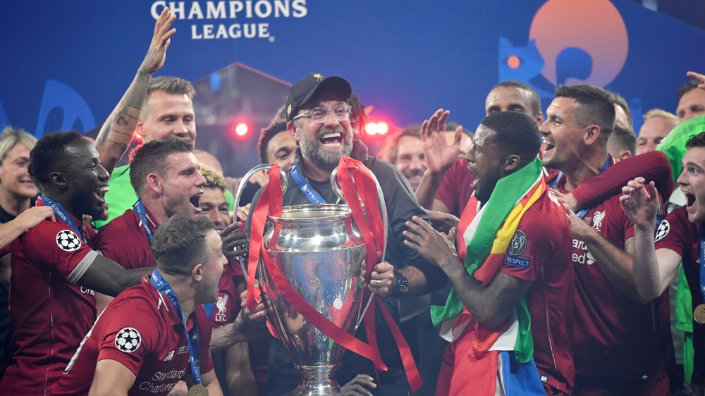 Liverpool manager Juergen Klopp lifts the trophy as the team celebrates after winning the Champions League