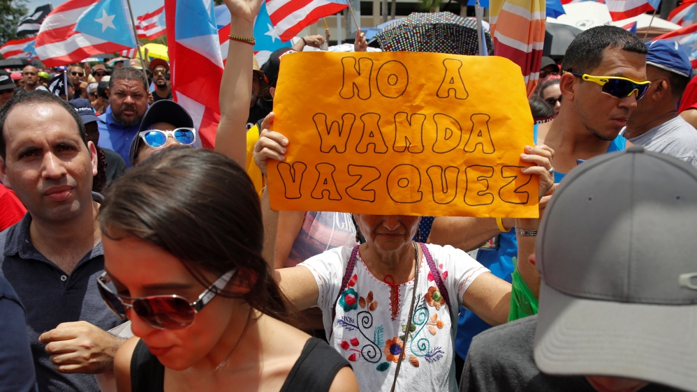 A woman holds a sign that reads