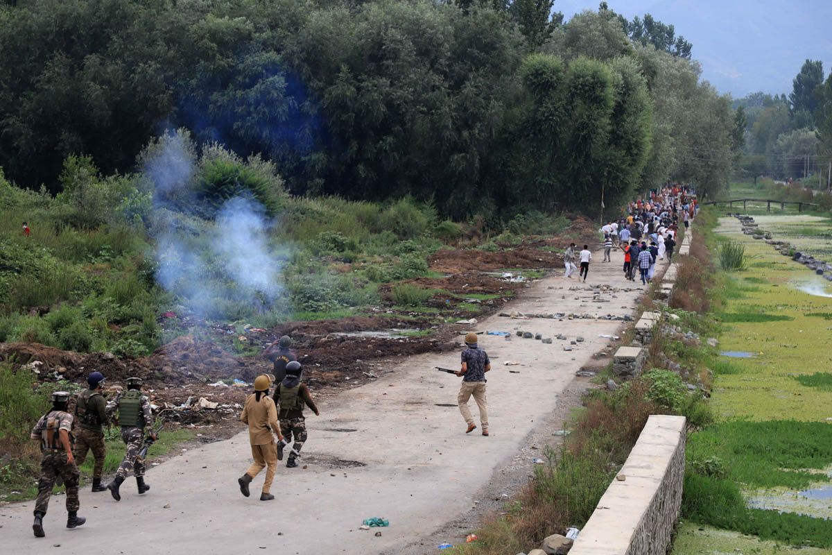 Indian police and paramilitary soldier’s fire teargas and pellets as they chase protesters during a clash in the outskirts of Srinagar city on august 9.
