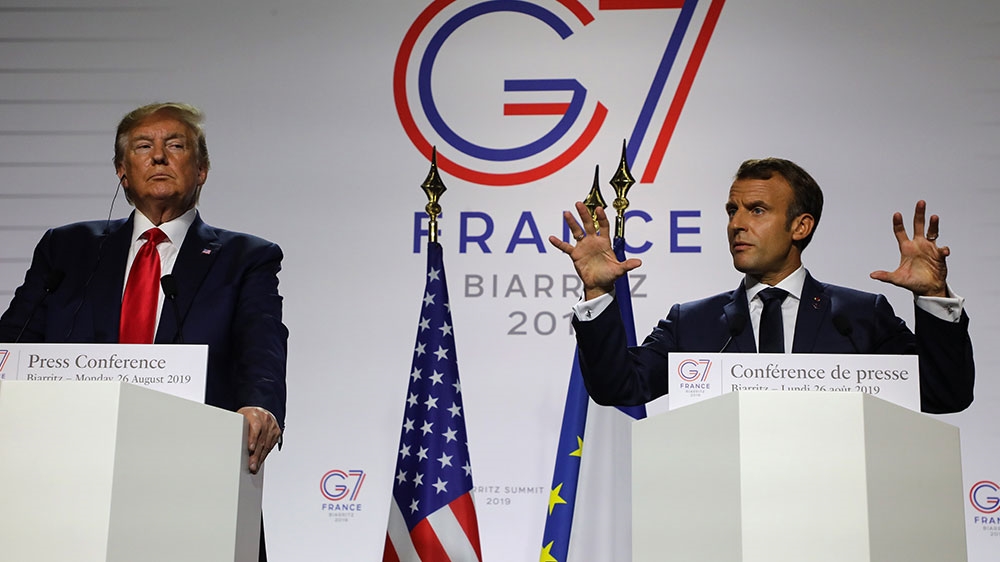 France’s President Emmanuel Macron gestures past US President Donald Trump during a joint-press conference in Biarritz on the third day of the annual G7 meeting