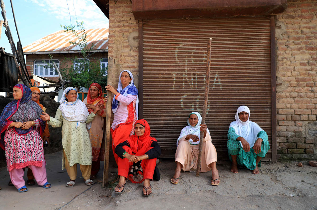 Women holding wooden sticks sit on a street in during clashes with forces in Anchaarsoura Srinagar on August 23, Jalla begum (middle) says we are here to protect our boys they are our honor ,the for