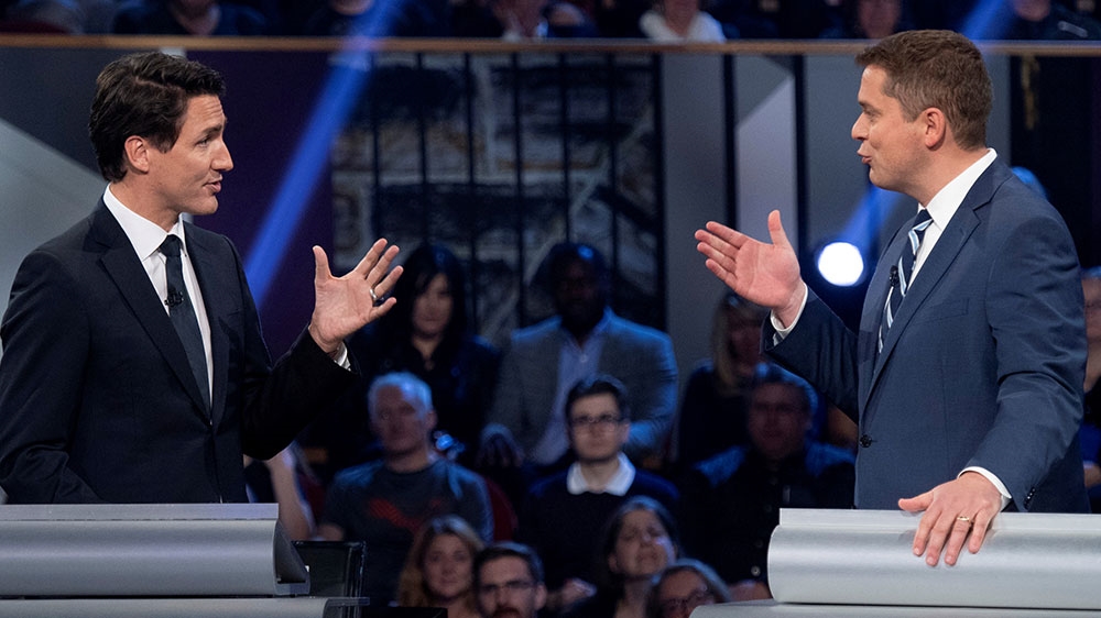 Conservative leader Andrew Scheer and Liberal leader and Canadian Prime Minister Justin Trudeau gesture to each other during the Federal leaders debate in Gatineau, Quebe