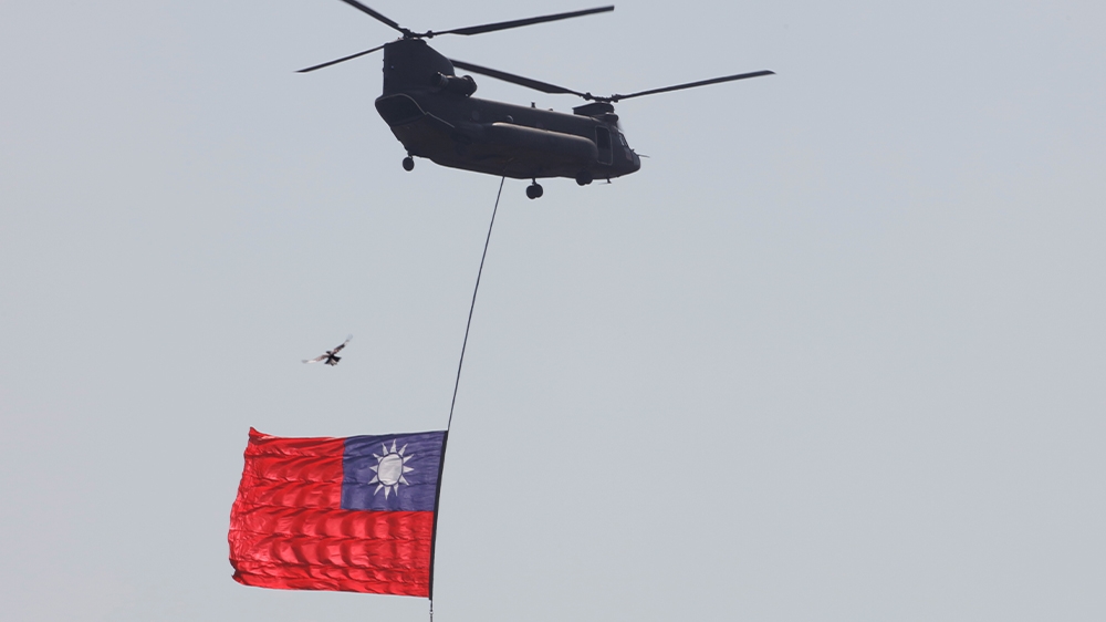 A helicopter carrying Taiwan’s national flag is seen during the National Day celebrations in Taipei
