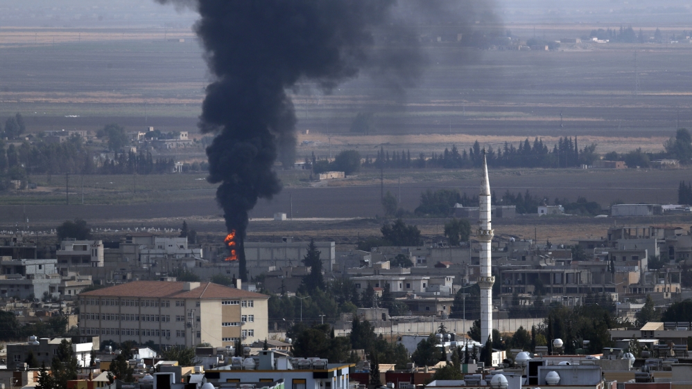 In this photo taken from the Turkish side of the border between Turkey and Syria, in Ceylanpinar, Sanliurfa province, southeastern Turkey, smoke billows from a fire in Ras al-Ain, Syria, Friday, October 18, 2019.