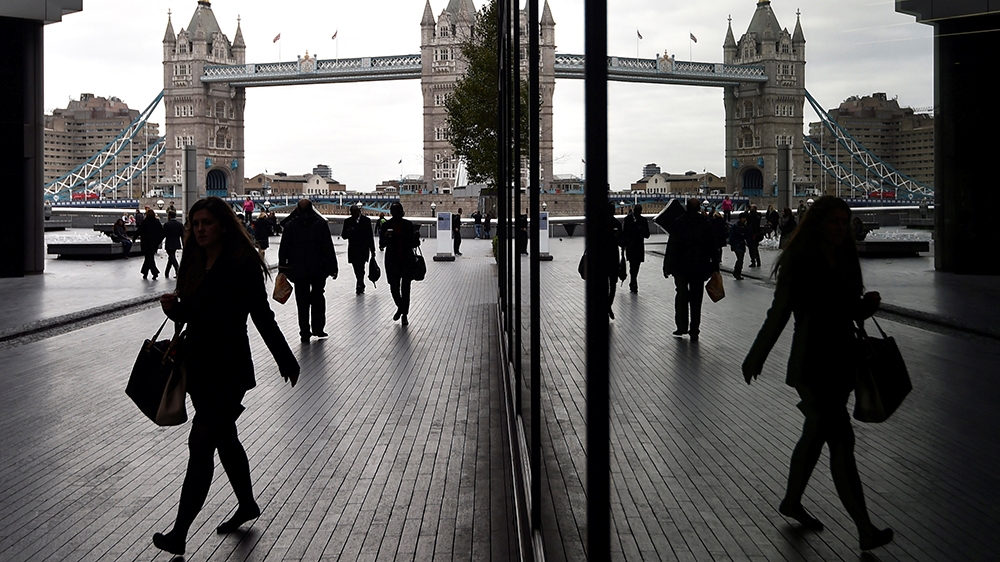 Workers walk through the More London business district with Tower Bridge seen behind in London, Britain, November 11, 2015