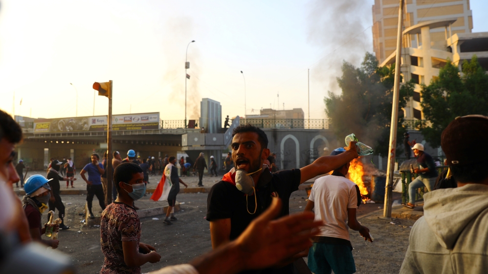 An Iraqi demonstrator reacts as protesters clash with Iraqi security forces during the ongoing anti-government protests in Baghdad
