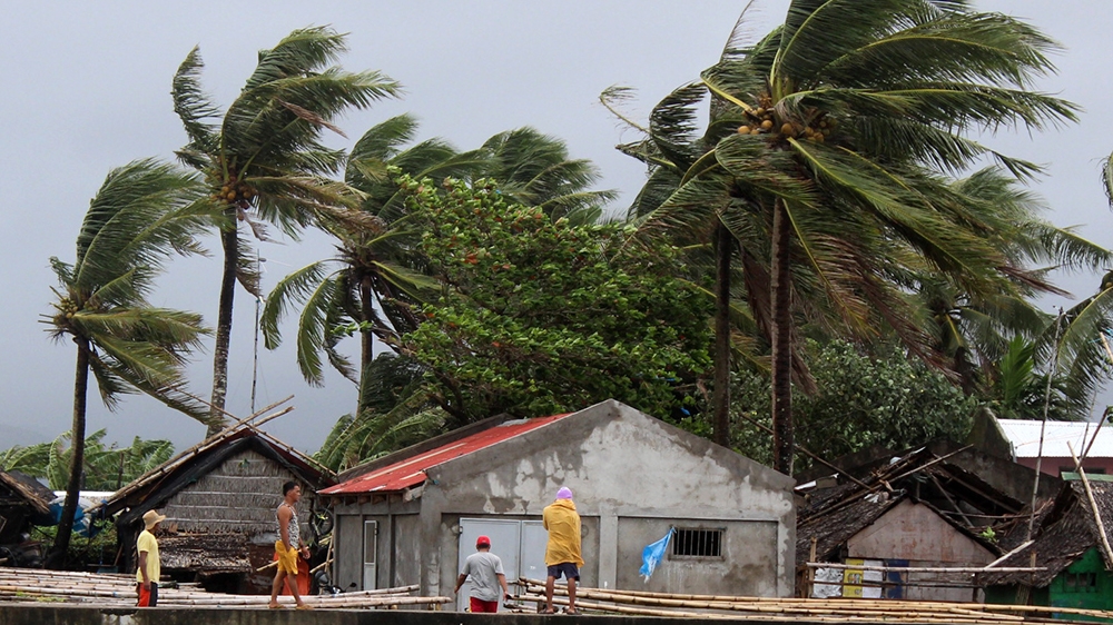 Villagers view strong winds blow trees next to houses in the town of Calabanga, Camarines sur province, Philippines, 02 December 2019. According to the latest government weather bureau forecast, a typ