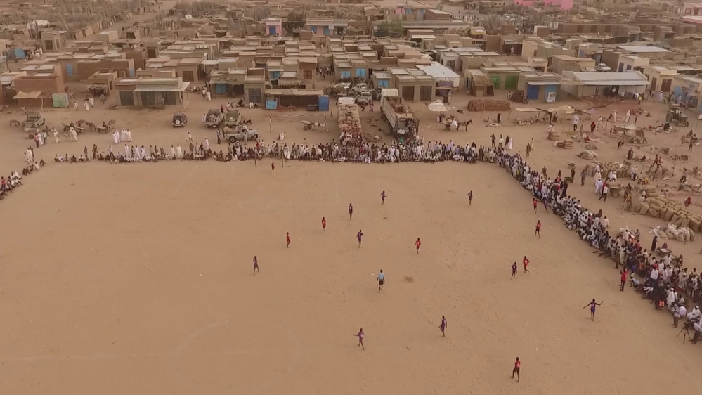 The boys play without proper boots or cleats within the Abu Shouk refugee camp. [Al Jazeera]