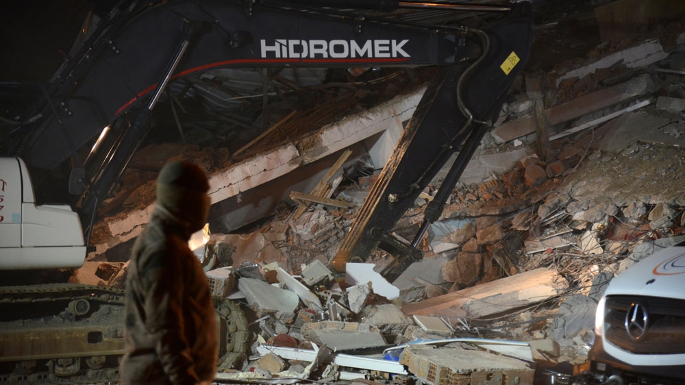 Turkish officials and police work at the scene of a collapsed building