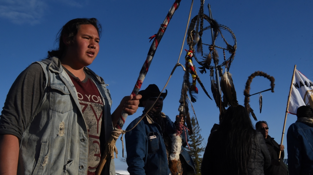 Tatanka Itancan Lone Eagle, a Fort Laramie treaty rider, holds a sacred staff during a ceremony to welcome other riders to the group in their communal encampment in Harrison, Nebraska