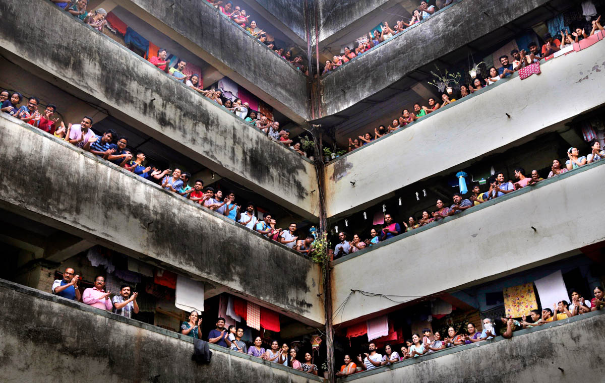 People clap from balconies in show of appreciation to health care workers at a Chawl in Mumbai, India, Sunday, March 22, 2020. India is Sunday observing a 14-hour "people''s curfew" called by Prime Min