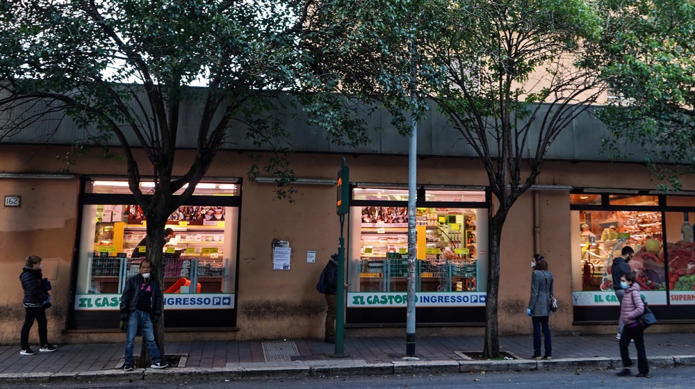 Lines extend down the block outside a neighbourhood supermarket on the outskirts of Rome