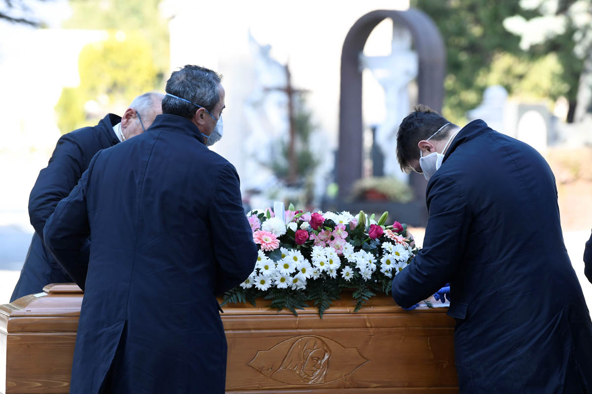 Cemetery workers and funeral agency workers in protective masks transport a coffin of a person who died from coronavirus disease (COVID-19), into a cemetery in Bergamo, Italy March 16, 2020. REUTERS/F