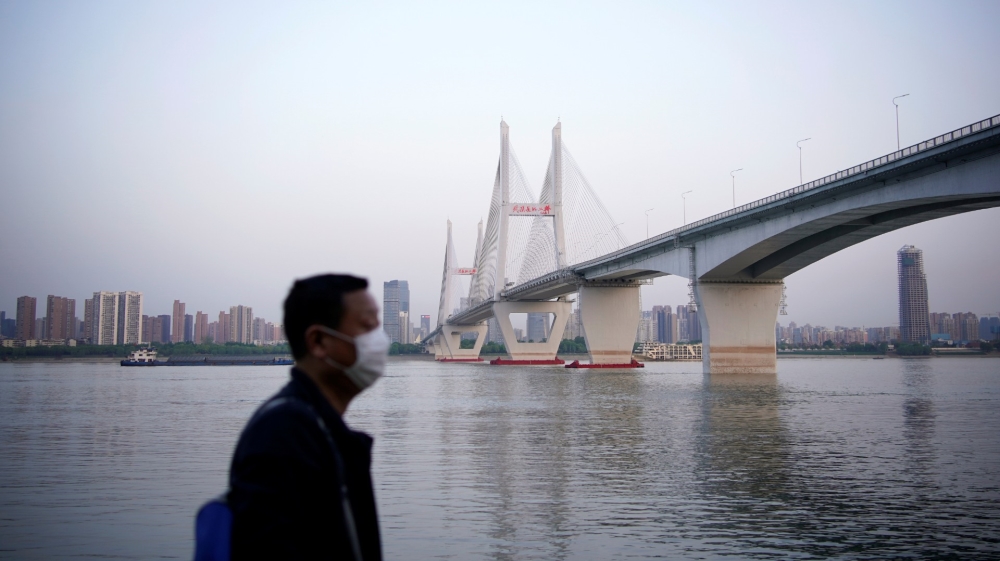 A man wearing a face mask is seen under a bridge of Yangtze river in Wuhan