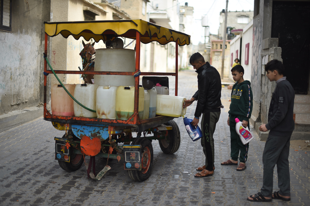Children buy cleaning products from a pedlar in a camp in Khan Yunis, southern Gaza Strip. Chlorine is the disinfectant in highest demand right now.