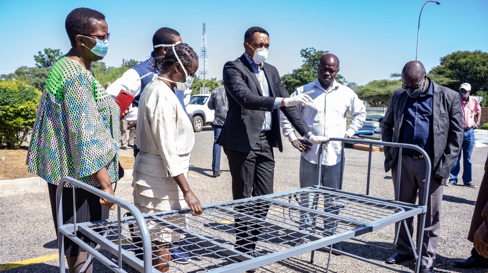 Businesspeople and government officials look at a sample bed for Ekusileni Hospital, an unused private medical facility in Bulawayo that is set to be turned into a COVID-19 testing and treatment centre