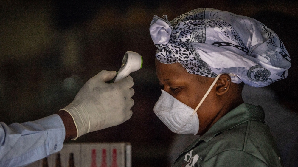A woman gets her temperature tested before she enters a supermarket in Bulawayo