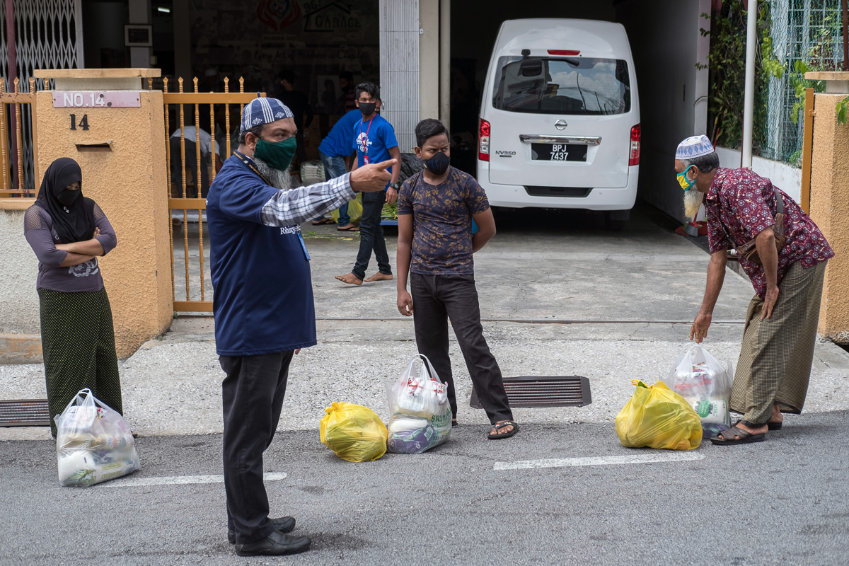 Rohingya refugees observe social distance during the collection of dry and fresh food at a community centre at the outskirts of Kuala Lumpur.