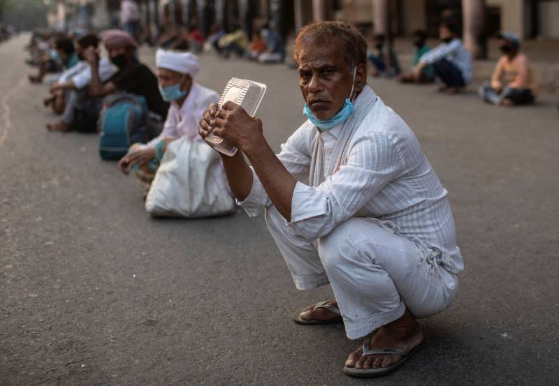 Daily wage labourers in New Delhi wait to receive food handouts during India’s coronavirus lockdown. The ILO predicts many will soon have no work at all