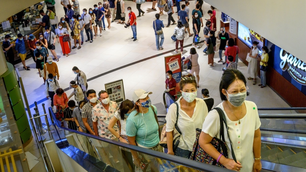 People stand in line to enter the Siam Paragon shopping mall in Bangkok