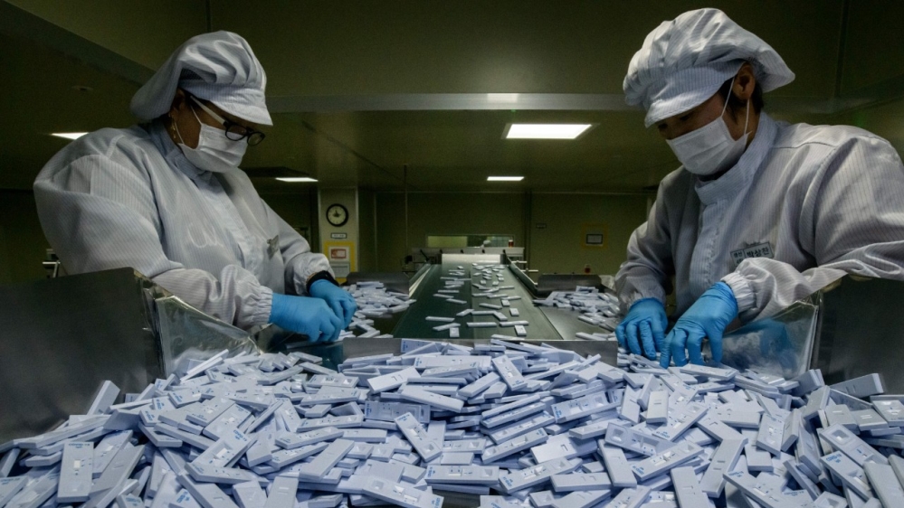 Sample testing devices used in diagnosing coronavirus are checked on a production line near Seoul