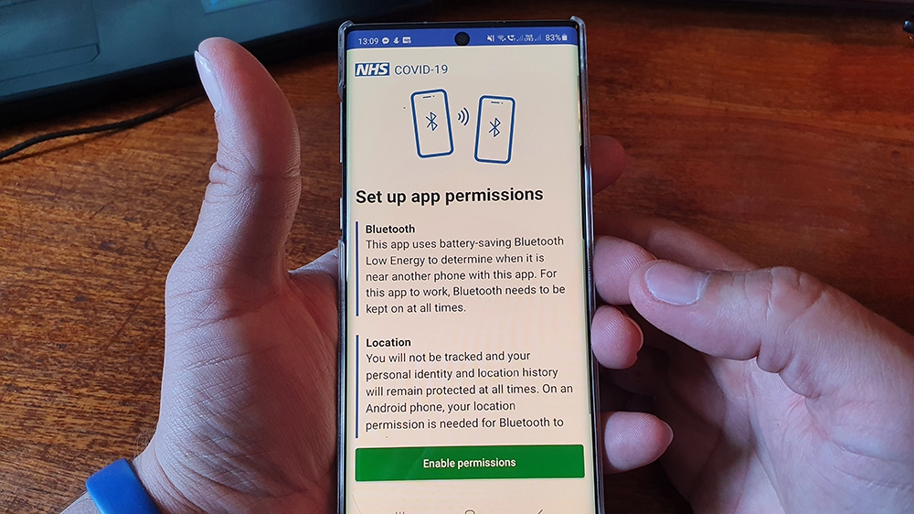 A resident of the Isle of Wight poses with his smartphone showing the newly released NHS Coronavirus contact tracing app in Ryde [AFP]