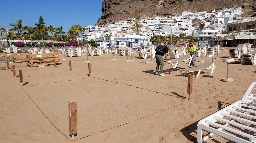 Workers prepare the beach to comply with social distancing requirements in Mogan, Gran Canarias, Spain