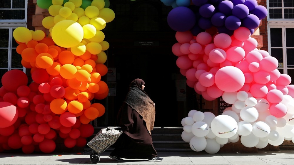 A Muslim woman walks past balloons outside London’s National Hospital for Neurology and Neurosurgery as the spread of the coronavirus disease (COVID-19) continues