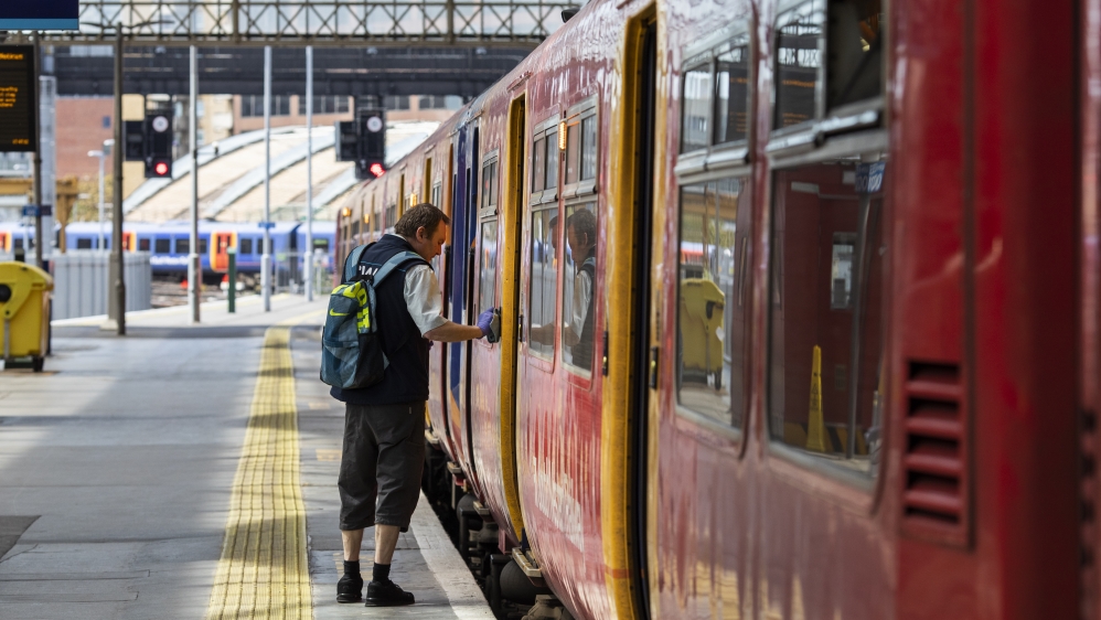A worker disinfects door release buttons at Waterloo Station in London, England