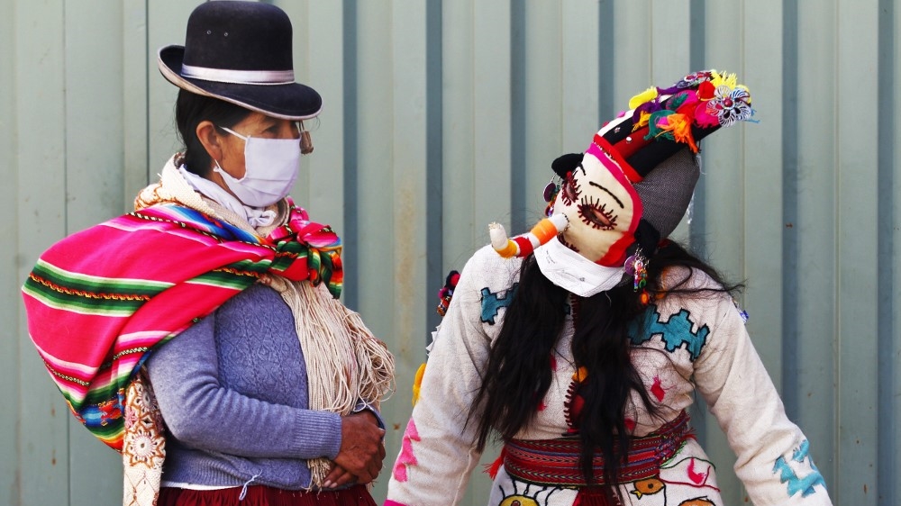 A person dressed as a Kusillo, a traditional Andean harlequin, reminds people to wear face masks, gloves and maintain a social distance as a preventive measure against the novel coronavirus COVID-19 in Puno, Peru