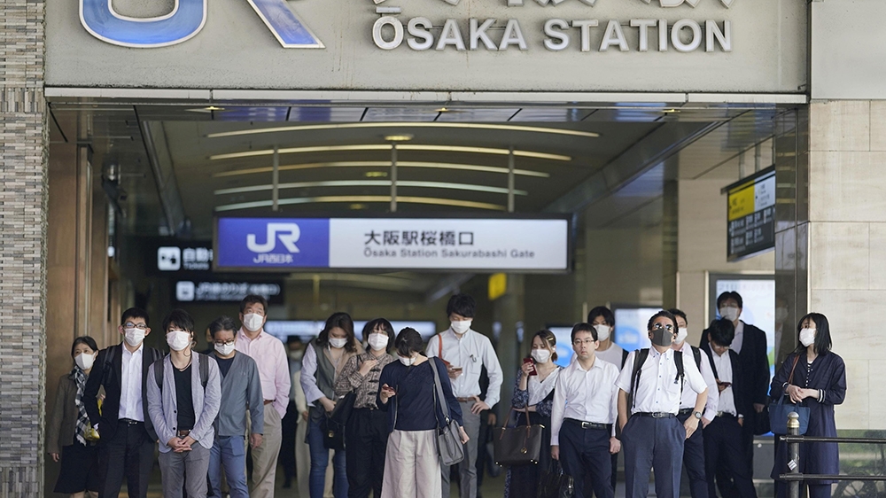 Commuters wearing protective masks head to work amid the coronavirus outbreak in Osaka, Japan
