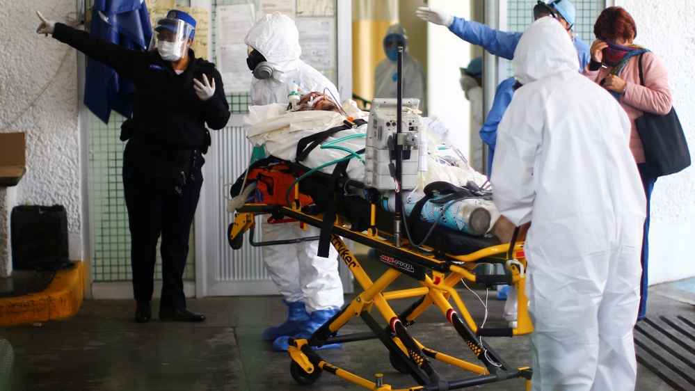 Healthcare workers wearing protective suits transporting a man suspected of being infected with the coronavirus in Mexico City, Mexico